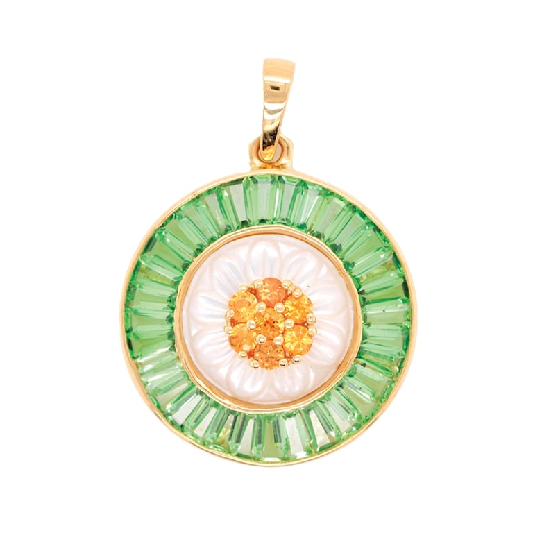 May include: A gold pendant with a floral design. The pendant features a white center with a cluster of orange gems, surrounded by a ring of green baguette-cut stones. The outer edge is gold, and the pendant has a gold bail.