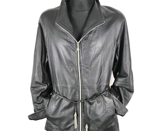 May include: Black leather jacket with a zip-up front, a collar, and a matching belt. The jacket has long sleeves and is displayed on a black mannequin. The belt has decorative silver tassels.
