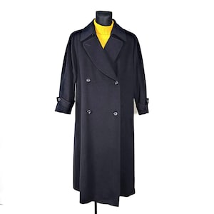 May include: A long, black double-breasted coat with a classic design. The coat has a high collar and is made of a smooth, luxurious fabric.