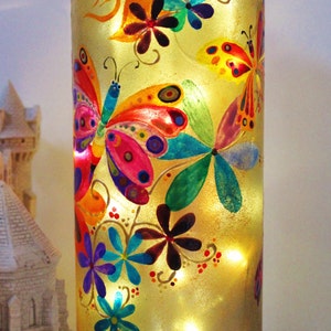 Large hand-painted glass lamp on the theme of multicolored butterflies that evolve among the flowers, unique, signed and numbered