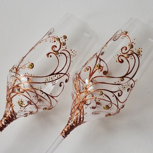 Two pretty hand-decorated stemmed glasses, customizable, representing copper scrolls decorated with small golden rhinestones