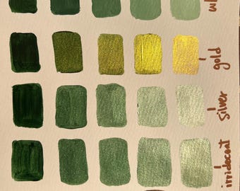 Puede incluir: Una tarjeta de muestras de acuarela etiquetada como "Mulberry" con muestras de pintura rectangulares. Los colores van del verde oscuro al oro, la plata y el cobre, con opciones blancas e iridiscentes. La tarjeta muestra varios tonos para uso artístico.