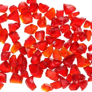 Könnte beinhalten: Eine Streuung von roten und orangefarbenen Glasstücken, wahrscheinlich für die Verwendung in einer dekorativen Vase oder einem anderen Bastelprojekt.