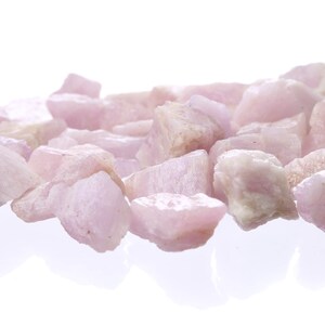 May include: A pile of pink and white tumbled stones. The stones are smooth and have a natural, polished look.