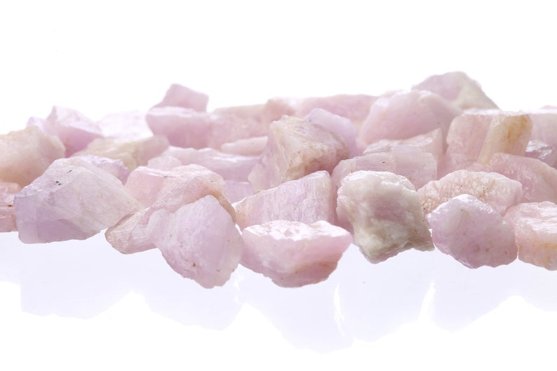 May include: A pile of pink and white tumbled stones. The stones are smooth and have a natural, polished look.