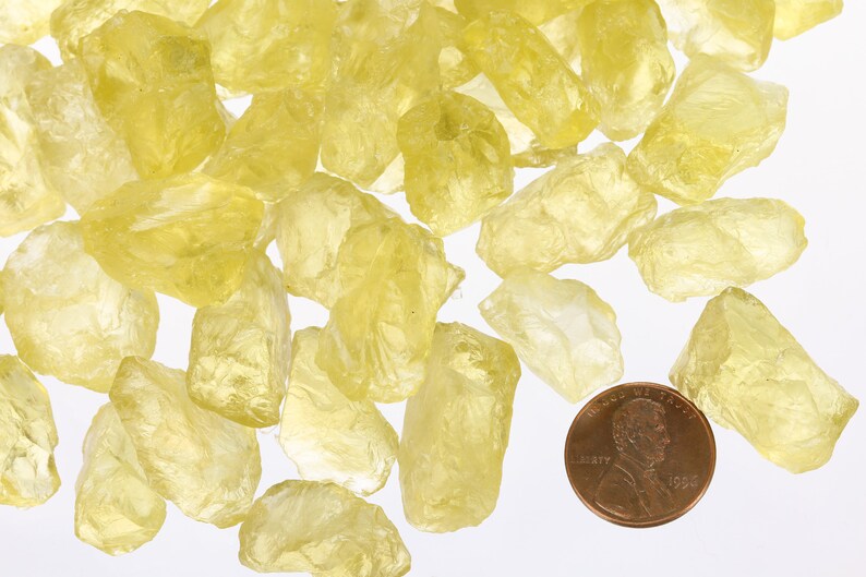 Pu&ograve; includere: Una collezione di cristalli di citrino giallo grezzi, di dimensioni che vanno da piccole a medie. I cristalli sono traslucidi e hanno un colore giallo chiaro. Un centesimo &egrave; incluso per la scala.