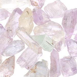 May include: A collection of pale pink, white, and green gemstone crystals. The crystals are rough and have a natural, unpolished look.