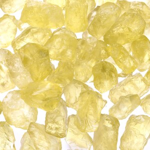 Pu&ograve; includere: Una collezione di cristalli gialli, traslucidi, tagliati grezzi. I cristalli sono di varie dimensioni e forme, e sono sparsi su uno sfondo bianco.