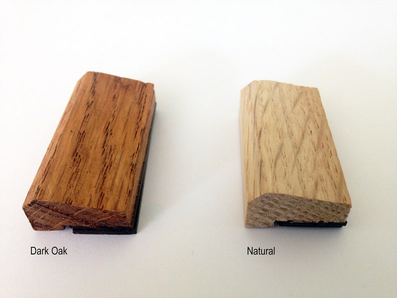 May include: Two wood samples, one stained dark oak and the other natural, with a black backing.