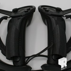 May include: A pair of black VR controllers with textured grips and buttons. The controllers are connected by a black cord.