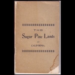 May include: A vintage book cover with the title "THE Sugar Pine Lands of CALIFORNIA." The cover is a faded tan color with black text and decorative lines. The edges show signs of wear and age.