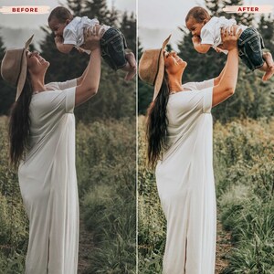 May include: A woman in a long, cream-colored dress and a wide-brimmed hat holds a baby in the air. The baby wears a white shirt and blue jeans. The background is a field with tall grass and trees.