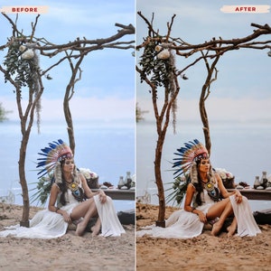 May include: A woman wearing a Native American headdress with blue and red feathers, seated on a sandy beach. She is dressed in a white dress and adorned with jewelry. A wooden structure with floral arrangements frames the scene, with the ocean in the background.