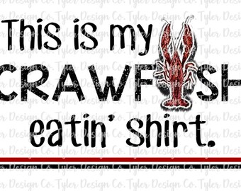 May include: Black and white text on a white background that reads "This is my crawfish eatin' shirt." A red crawfish illustration is to the right of the text.