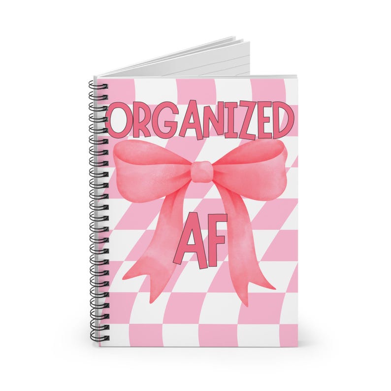 May include: A pink and white checkered notebook with a pink bow and the text "ORGANIZED AF" in pink.