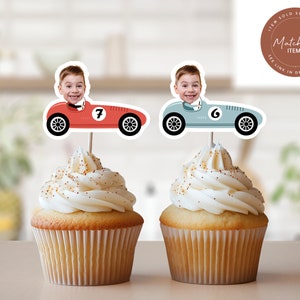 K&ouml;nnte beinhalten: Zwei Cupcake-Topper mit einem roten und einem blauen Rennwagen, in denen ein Junge am Steuer sitzt. Der rote Wagen hat die Nummer 7 und der blaue Wagen die Nummer 6. Die Topper befinden sich auf Cupcakes mit wei&szlig;em Frosting.