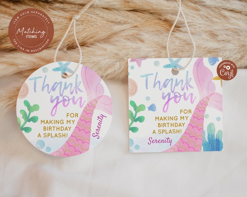 May include: Two round thank you tags with a mermaid tail design. The tags are pink, purple, and blue with gold glitter accents. The text on the tags reads "Thank you for making my birthday a splash!" and "Serenity".