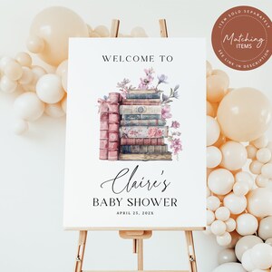 May include: A white sign with the text "Welcome to Claire's Baby Shower April 25, 202X" and a stack of vintage books with flowers on top.