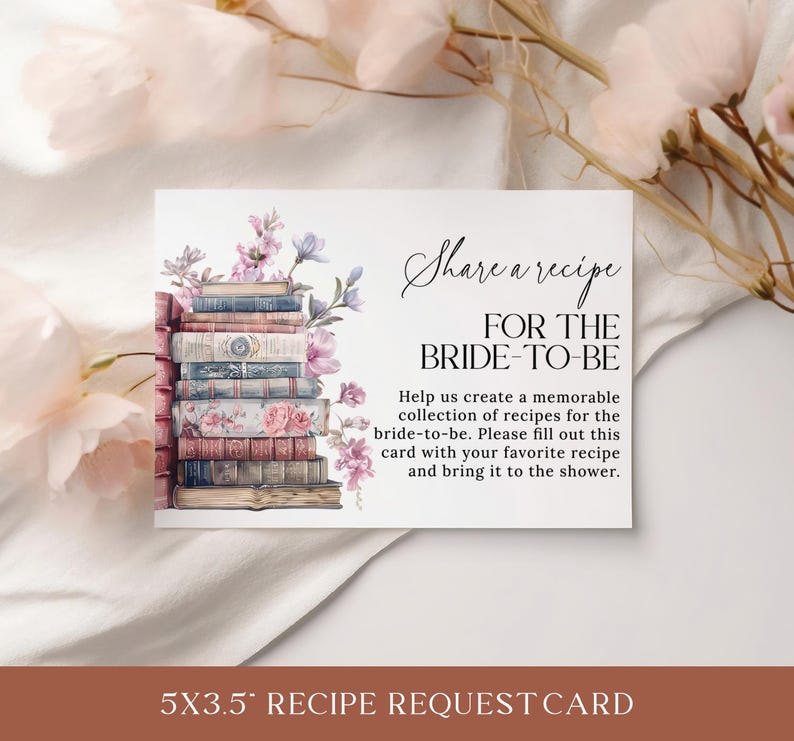 May include: A white card with a floral design and a stack of books. The text on the card reads "Share a recipe for the bride-to-be. Help us create a memorable collection of recipes for the bride-to-be. Please fill out this card with your favorite recipe and bring it to the shower."