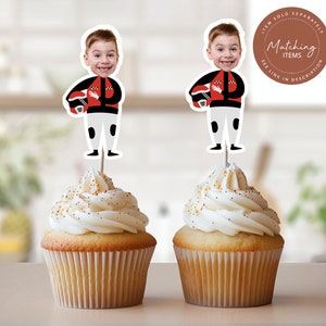 May include: Two cupcakes with white frosting and gold sprinkles topped with edible images of boys wearing racing helmets and suits. The images are on toothpicks and say "Matching Items" on the top.
