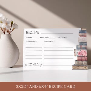 May include: A blank recipe card with a stack of vintage books on the right side. The card has lines for writing down the recipe title, servings, prep time, cook time, ingredients, and directions. The text "from the kitchen of" is at the bottom of the card. The card is 5x3.5 inches or 6x4 inches.