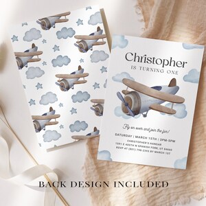 May include: A blue and brown airplane with clouds and stars on a white background. The text "Christopher is turning one" is at the top of the invitation. The text "Fly on over and join the fun!" is below the airplane. The text "Saturday March 15th 3PM-5PM" is below the text "Fly on over and join the fun!" The text "Christopher's Hangar" is below the date and time. The text "1541 E 400th N Spanish Fork, UT 84660" is below the hangar name. The text "RSVP at (801) 798-2393 by March 1st" is below the address. The text "Back Design Included" is at the bottom of the invitation.