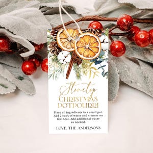 Op de afbeelding: Een printbare cadeau-tag met een aquarel-illustratie van gedroogde sinaasappels, kaneelstokjes en groen. De tekst luidt "Stovetop Christmas Potpourri" en bevat instructies voor het maken van de potpourri. De tag is perfect om een ​​zelfgemaakt cadeau een persoonlijke touch te geven.