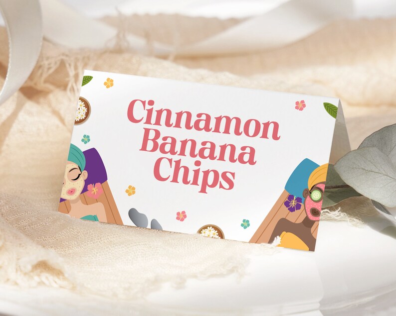 Op de afbeelding: Een witte kaart met de tekst "Cinnamon Banana Chips" in roze letters. De kaart is versierd met illustraties van twee vrouwen met gezichtsmaskers, bloemen en een spa-achtige omgeving.