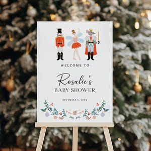 May include: A white sign with a Nutcracker, a ballerina, and a mouse king illustration. The sign says "Welcome to Rosalie's Baby Shower, December 8, 20XX".