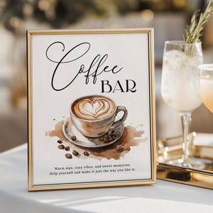 Op de afbeelding: Een goudkleurig ingelijst bord met de tekst "Coffee BAR". Het bord toont een aquarel illustratie van een koffiekopje met een hartvormig ontwerp in het schuim, omringd door koffiebonen en een koffievlek.