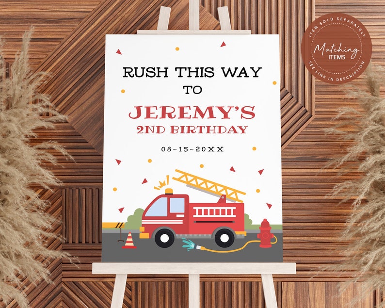 May include: A white sign with red and yellow accents, announcing "RUSH THIS WAY TO JEREMY'S 2ND BIRTHDAY 08-15-20XX". The sign features a cartoon red fire truck with a ladder, a yellow fire hydrant, and a yellow and orange traffic cone.
