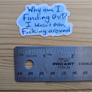 Pode incluir: Um autocolante com o texto "Why am I Finding Out? I wasn't even Fucking around" em tinta azul sobre fundo branco. Uma r&eacute;gua est&aacute; por baixo.