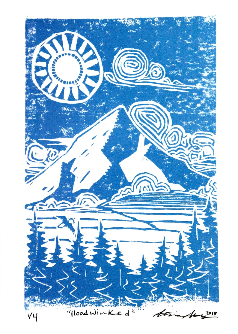 May include: A blue and white linocut print of a mountain landscape with a sun, clouds, and trees. The print is titled "Hoodwinked" and signed by the artist.