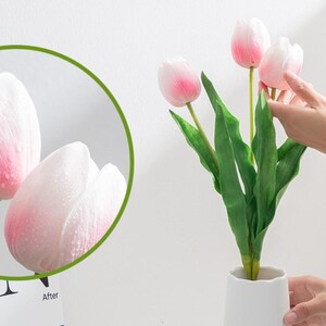 May include: A bouquet of pink artificial tulips with green leaves in a white vase. The tulips have a soft, velvety texture.