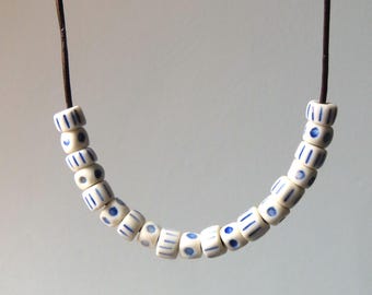 Porcelain beaded necklace hand made in Scotland. Threaded on a leather cord 52cm long with lobster clasp. In a hessian gift bag.