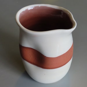 Cream and red slip decorated dimple jug. Hand made in Scotland 10cm tall holds 250ml. Suitable for milk, cream and sauces, water for whisky