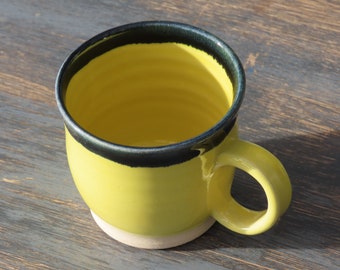 200ml small Hand thrown yellow stoneware mug with inky blue rim detail. made in Scotland by Jenny Finch. 7cm tall x 8cm wide. Signed on base
