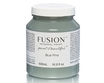 May include: A jar of Fusion Mineral Paint in Blue Pine. The jar is a light blue-green color with a white lid. The label reads "Fusion Mineral Paint" and "paint it beautiful". The jar contains 16.9 fl oz (500mL) of paint.