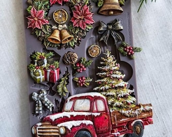 May include: A grey silicone decor mould titled Country Christmas Delivery featuring various holiday-themed shapes including a poinsettia wreath with bells, a bell with holly, a bow, a pinecone, gift boxes, a Christmas tree, and a red pickup truck.