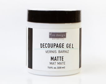 May include: A white jar of Re-Design Decoupage Gel with a black lid. The label reads "Decoupage Gel, Vernis Barniz, Matte, Mat Mate, 7.8 fl. oz. (230 ml)"