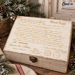 May include: A rectangular wooden box with a distressed white finish and gold-toned script text. The lid features the words Silent Night, Le Follet, and Courrier des Salons, along with vintage-style circular stamps and a metal latch on the front.