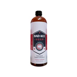 May include: A brown bottle of "BAD ACE SOAP" paint brush cleaner and preserver. The label is white with a black and red design, including the text "Lemon Verbena" and "16 FL. OZ. (473 mL)". The bottle has a black cap and is against a white background.
