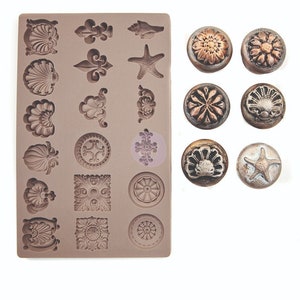 May include: A brown silicone mold with various seashell, floral, and geometric designs. Also, six decorative buttons with similar embossed patterns, including a starfish and a flower. The buttons have metallic bronze and silver finishes.
