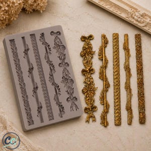 May include: A rectangular gray silicone mold featuring five distinct linear decorative patterns, accompanied by five corresponding gold-colored cast pieces. The designs include floral garlands, twisted rope textures, and intricate botanical motifs.