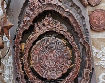 May include: A silicone decor mould set titled Evergreen & Embers featuring brown, tree-ring-shaped, and mountain-shaped cavities. The packaging includes text such as Decor Moulds, Evergreen & Embers, and indicates it is a 1-piece set.