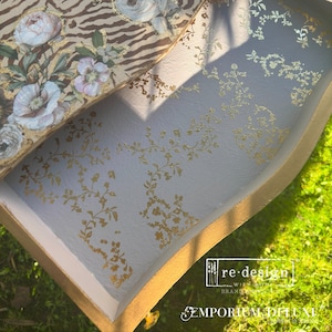 Puede incluir: Primer plano de un caj&oacute;n con un interior azul claro y un borde dorado. El caj&oacute;n est&aacute; decorado con un patr&oacute;n floral dorado. El caj&oacute;n est&aacute; abierto y el interior es visible. El texto "re-design with Ruth" y "EMPORIUM DELUXE" es visible en el caj&oacute;n.