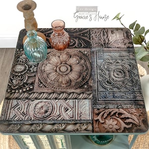 May include: A teal blue end table with a decorative top featuring a mosaic of brown and gray patterned tiles. The table has a lower shelf with books and a glass vase.