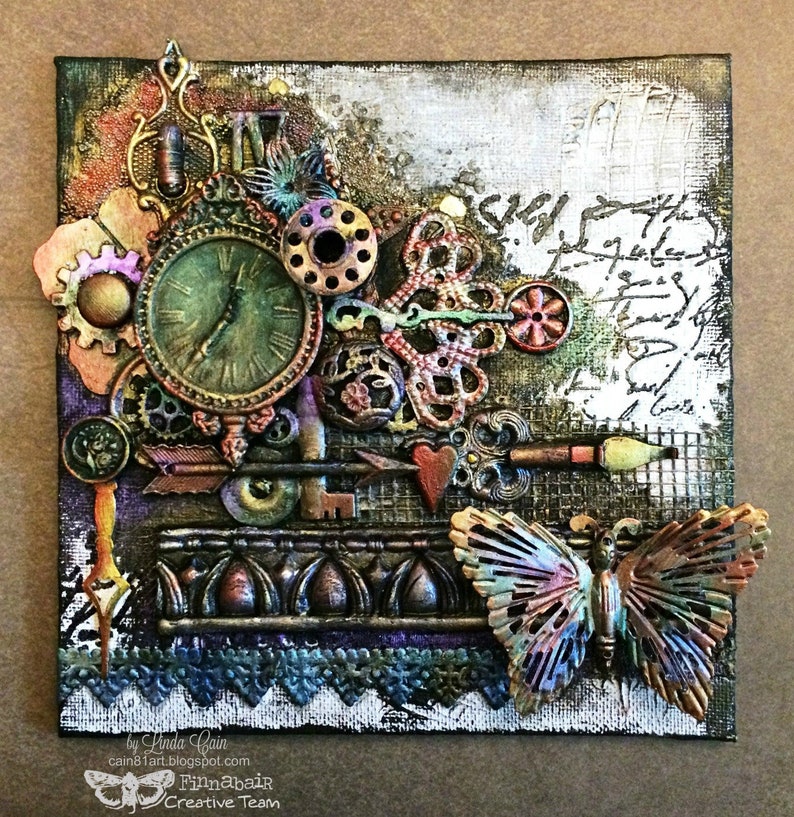 May include: A mixed media canvas art piece with a steampunk theme. The artwork features a clock face, gears, keys, a butterfly, and a paintbrush. The background is a textured canvas with a white wash and black script.