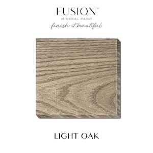 May include: A square, light oak wood sample with visible grain patterns. The sample is a neutral beige color. The text "FUSION MINERAL PAINT" and "finish it beautiful" are at the top. The text "LIGHT OAK" is at the bottom.
