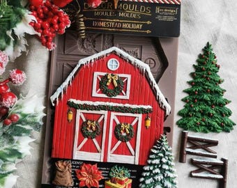 May include: A silicone mold for crafting featuring a red barn with white trim, snow-covered roof, and holiday wreaths. The packaging displays the text Homestead Holiday, Re-design with Prima, and 5 inches by 8 inches. Includes molded accents.